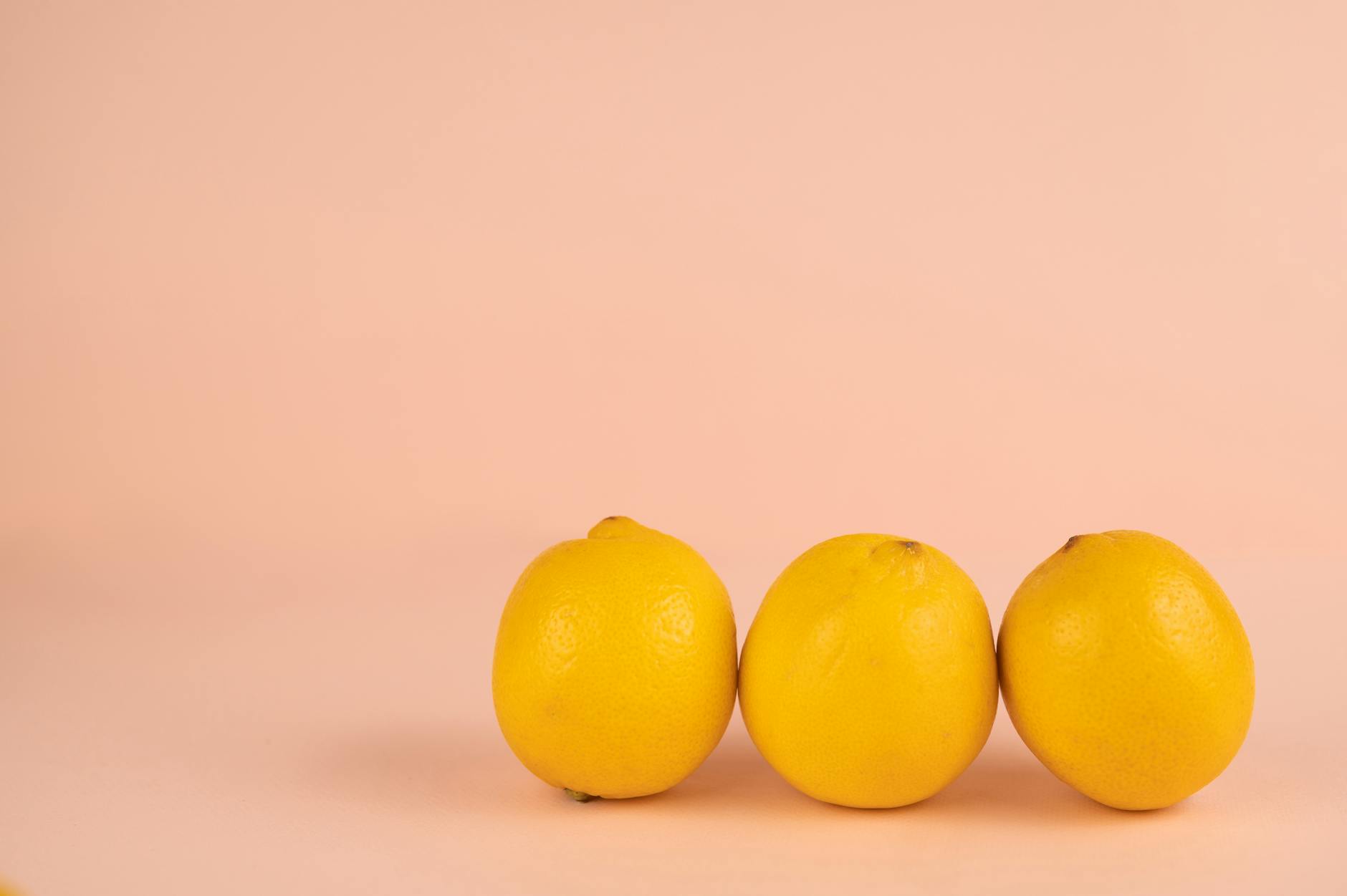 Leuchtend gelbe Zitronen auf pastellfarbenem Hintergrund, symbolisierend die Lemon Vibrator Technologie